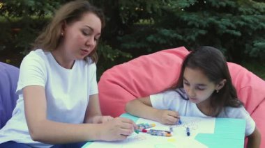 Şirin anne ve kızı yaz gününde bir parkta oturan çizim.