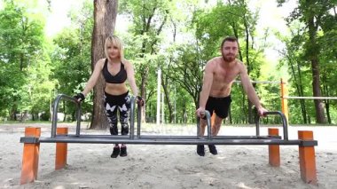 Genç sportif kadın ve bir parrk alýþtýrmalarda şınav yaz gününde yapan sakallı erkek.
