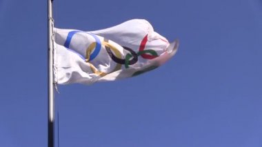 Olimpiyat bayrağı mavi gökyüzü arka plan üzerinde bir rüzgar tasa.
