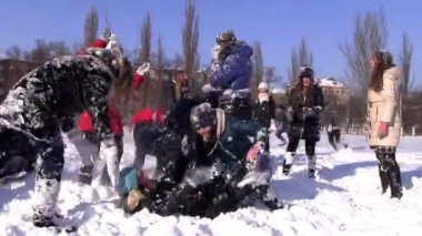Üniversite öğrencileri kampüs kartopu Savaşı güneşli kış gününde.