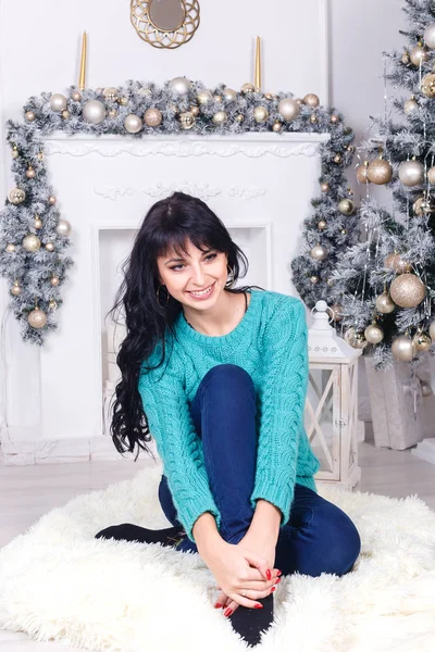Mutlu genç kadın uzun saçlı kapalı Noel oturuyor