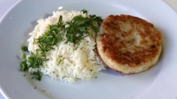 Schnitzel mit Reis und Gemüse auf einem rotierenden weißen Teller — Stockvideo