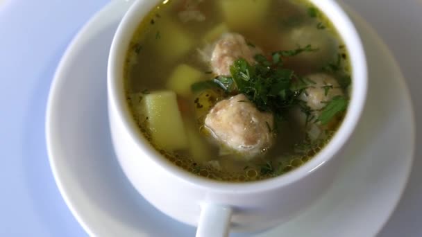 Суп с мясом и картошкой на вращающейся белой тарелке — стоковое видео