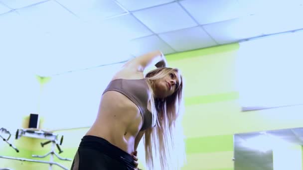 Atraktivní blondýnka mladá žena se zahřívá, skákání před tréninkem v tělocvičně. — Stock video