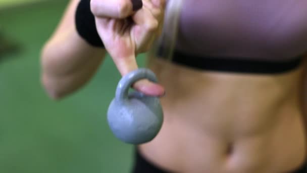 Mujer joven haciendo ejercicios con pesas en un GYM. Dedo que sostiene el peso de cerca . — Vídeos de Stock