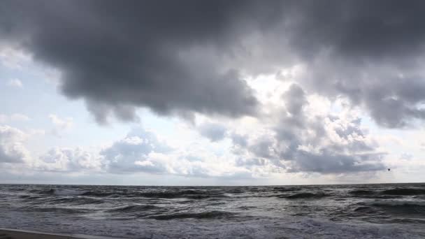 Tormenta en la playa de arena marina, nublado, el viento persigue olas y nubes . — Vídeos de Stock