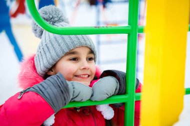 Mutlu kız kış soğuk gününde bir sahada oynamak.