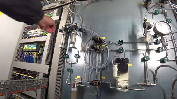 Ingenieur past de gasstroom op rotameter in schakelkast van het gassysteem van de analyse op de fabrieksinstallaties. Actiecamera Pov schot. — Stockvideo