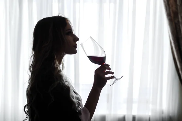 ローブに身を包んだ官能的な若い女性は、winegla からワインを飲む — ストック写真