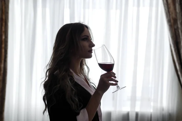 Zmysłowy, młoda kobieta, ubrany w szatę pije wino z winegl — Zdjęcie stockowe