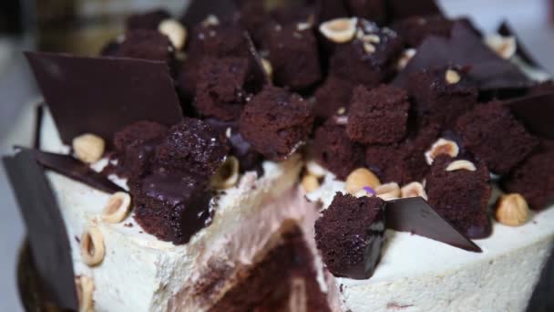 Heerlijke verse cake met noten en chocolade op spinnen tabel close-up. — Stockvideo