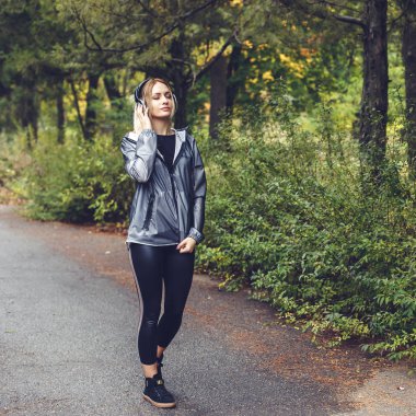 Çekici sarışın kız bir parkın, yürüyüş sahiptir m için dinleme