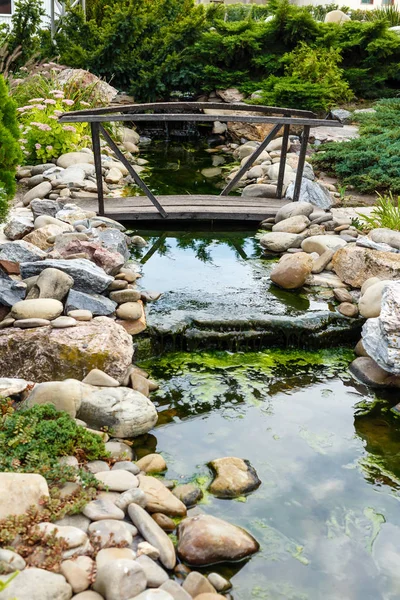 Puente de madera vintage sobre un arroyo con piedras en el parque de la ciudad . — Foto de Stock