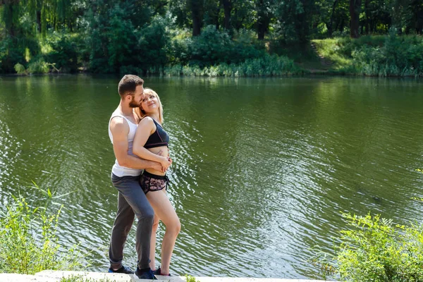 genç adam ve sarılma, Nehri yakınında bir parkta yürüyen bir kadın