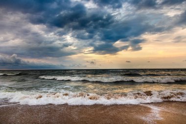 Bir sabah deniz manzarası üzerinde dramatik gökyüzü. Fırtına bir deniz kumlu plajda.