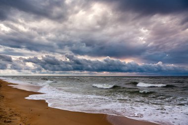 Bir sabah deniz manzarası üzerinde dramatik gökyüzü. Sunrise kumlu bir plaj üzerinde.