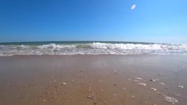 Okyanus dalgaları bir kamera bir güzel kumlu plajda bir güneşli yaz gününde koru. Eylem kamera düşük bir açıdan için çekim.