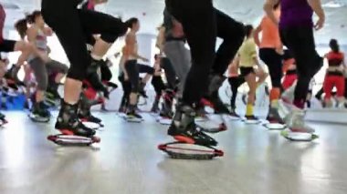 Grup genç sportif beyaz kadını kangoo ile fitnes egzersizleri yapıyor bir spor ayakkabı atlar.