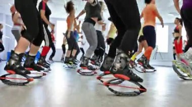 Grup genç sportif beyaz kadını kangoo ile fitnes egzersizleri yapıyor bir spor ayakkabı atlar.