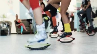 Grup genç sportif beyaz kadını kangoo ile fitnes egzersizleri yapıyor bir spor ayakkabı atlar.