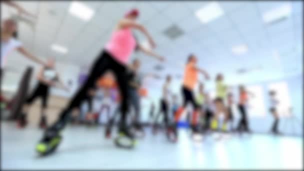 Grupo de jóvenes deportistas caucásicos haciendo ejercicios de fitnes con kangoo salta zapatos en un gimnasio . — Vídeo de stock