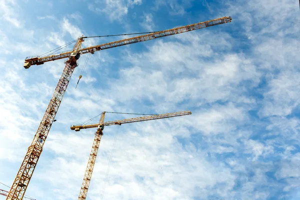Two high tower cranes work on construction of new homes