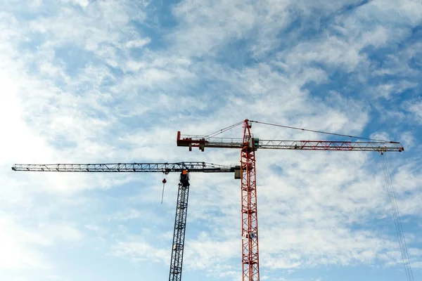 Two high tower cranes work on construction of new buildings. Stock Image