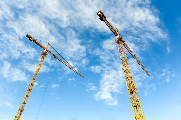 Dois guindastes de torre alta trabalham na construção de novas casas — Fotografia de Stock