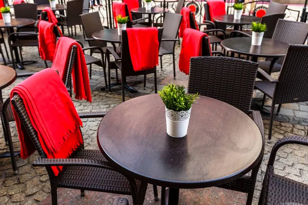 Empty tables and wicker chairs on paving stones in a cafe in old — Stock Photo, Image