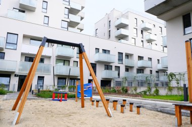 Modern konutların rahat avlusunda salıncaklı bir oyun alanı 