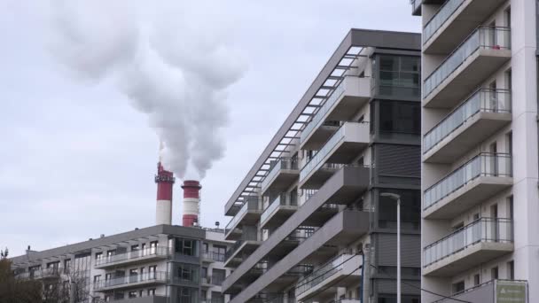 Dvě Trubky Teplárny Uvolňují Bílou Páru Mezi Moderními Městskými Budovami — Stock video