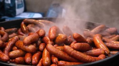 Açık kafede ızgara taze sosis ve barbekü. Panayırdaki aç turistler için tedavi