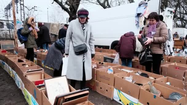 Mensen zitten op een vlooienmarkt. Mannen en vrouwen kiezen voor antiek op een rommelmarkt. — Stockvideo