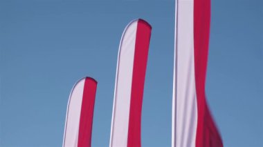 Many Polish flags on celebratin of Independence day of Poland on a blue sky background. Patriotic Consept.