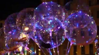 Renkli LED ışıkları olan balonlar eski turistik şehir merkezinin gece caddesinde satılıyor..