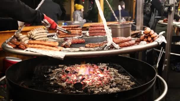 牛肉のグリルソーセージは 大きな鍋でオープン火災に揚げられています ストリートカフェは フェアで観光客のための御馳走を準備します — ストック動画