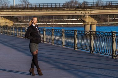 Güneşli bir günde sehirde yürüyen sevimli genç bir kadin..