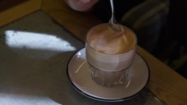 Closeup Young Woman Thoughtfully Slowly Mixes Coffee Froth Glass Cup — Stock Video