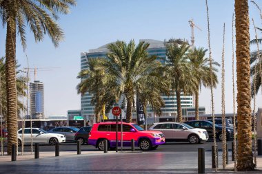 Dubai, UAE - Kasım 2013. Şehir trafiğinde pembe cip arabası. Güneşli bir günde şehir caddesinde çok araba var..