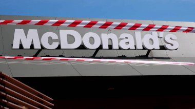 KRYVYI RIH, UKRAINE - Nisan, 2020. McDonald 's fast food restoranı kırmızı ve beyaz uyarı bantlarıyla çevrili. Covid 19 Coronavirus salgını nedeniyle karantinaya alındı.