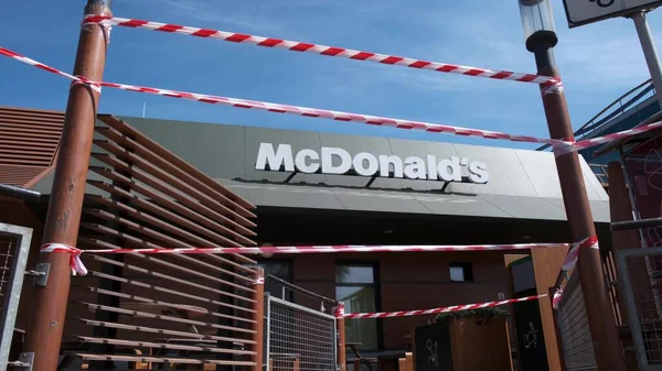 KRYVYI RIH, UKRAINE - Nisan, 2020. McDonald 's fast food restoranı kırmızı ve beyaz uyarı bantlarıyla çevrili. Covid 19 Coronavirus salgını nedeniyle karantinaya alındı.
