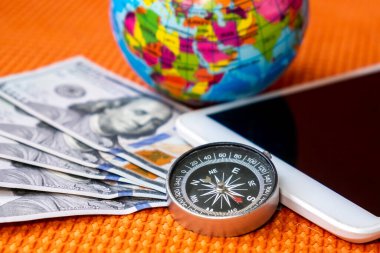 Beş yüz Amerikan Doları, Pusula, Dünya Gezegeni Küresi, Kumaş Arka plan Yakın plan Ipad. Seyahat, turizm, macera kavramı.