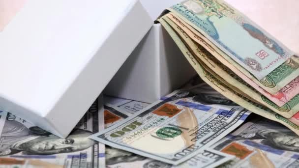 在旋转桌子上的美元钞票背景下的白色礼品盒中的阿联酋货币污垢 全球商业概念 — 图库视频影像