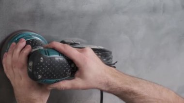 Yetenekli işçi duvarları elektrikli el değirmeni makinesiyle cilalıyor. Usta bir binada tamirat yapıyor..