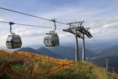 Two cable car cabins on the top of mountain clipart