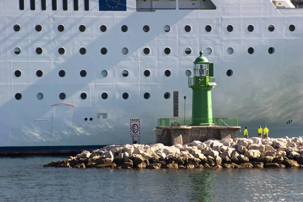 Farol verde na frente de um grande navio — Fotografia de Stock