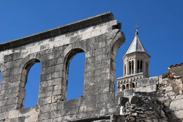 Arches and bell tower on blue sky — Stock Photo, Image