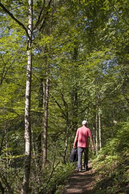 Sırt çantası orman yolu üzerinde olan adam
