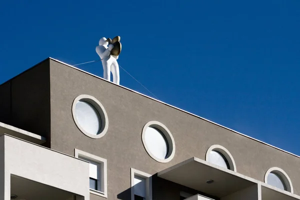 Plastic saxophonist on the roof of new building — Stock Photo, Image