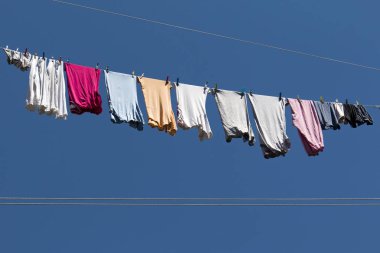 İç çamaşırı ve t-shirt halatlar üzerinde mavi gökyüzü güneşli rüzgarlı gün, kurutma